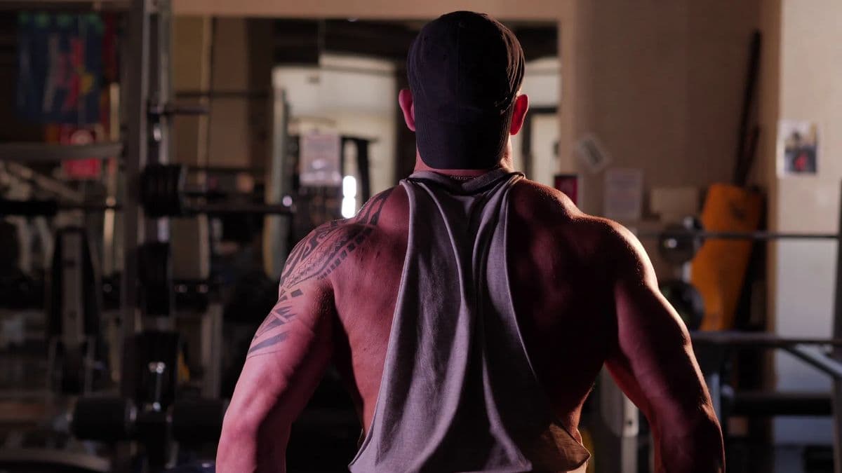 A man with a tattoo on his shoulder and lots of muscles facing away from the camera