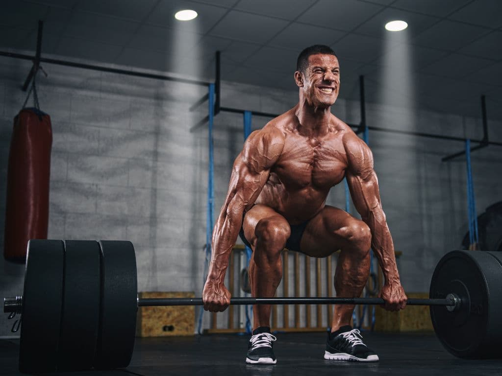 A man lifting heavy weights without a shirt on