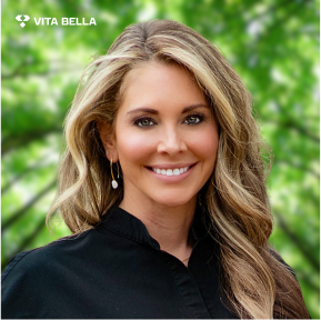 Dr. Brooke Blumetti, Chief of Dermatology at Vita Bella, with long blonde hair and a black top, against a green background