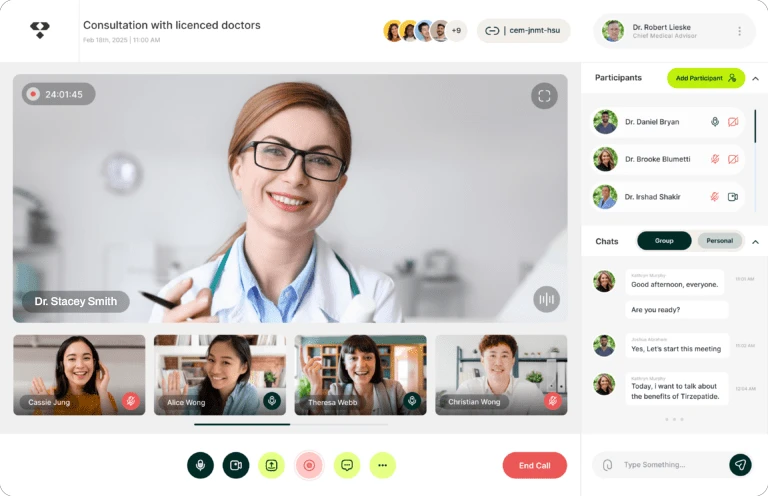 A screenshot of a Vita Bella virtual consultation interface, featuring the fictional Dr. Stacey Smith in a white coat on the main screen, with four other participants in smaller video windows, a participant list including the real Dr. Robert Lieske and Dr. Brooke Blumetti, and a chat window on the right.